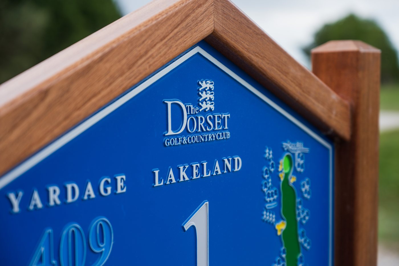 A JB Golf Group hardwood tee sign at Flackwell Heath Golf Club, up close